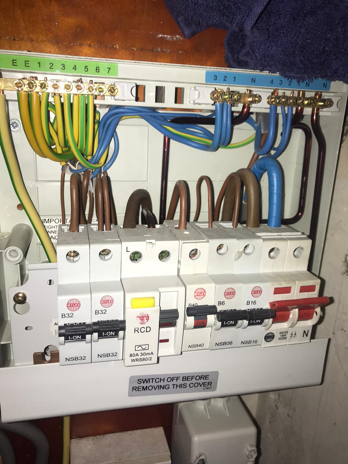 Electrician working on a consumer unit safely