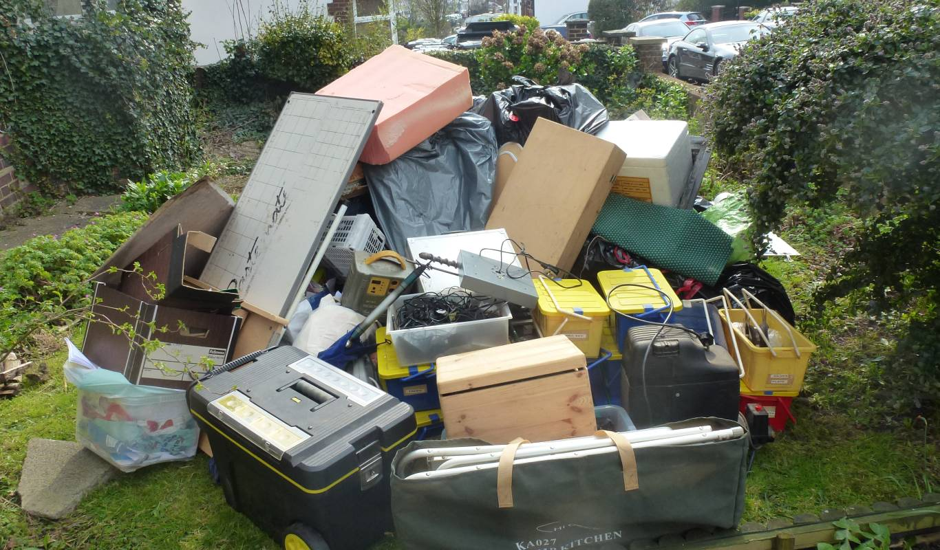 Waste removal team loading debris into a van